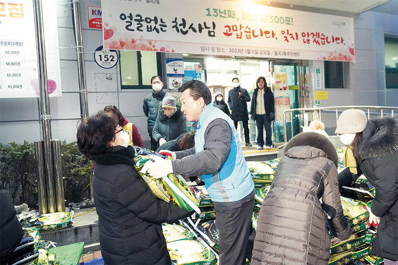 쌀 포댜 옮기는 직원들과 자원봉사자들